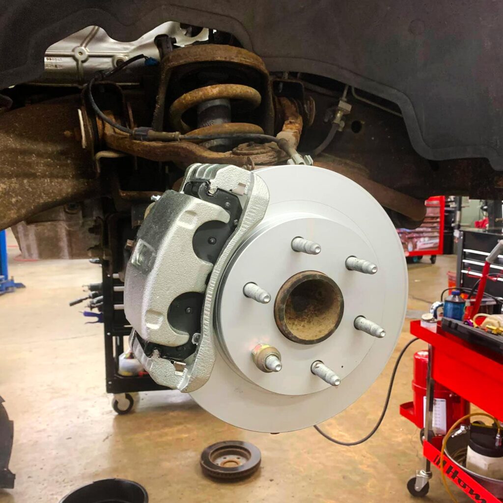 New brake pads, caliper, and rotor installed with wheel removed at Local Wrench Auto Repair in Belfair, WA