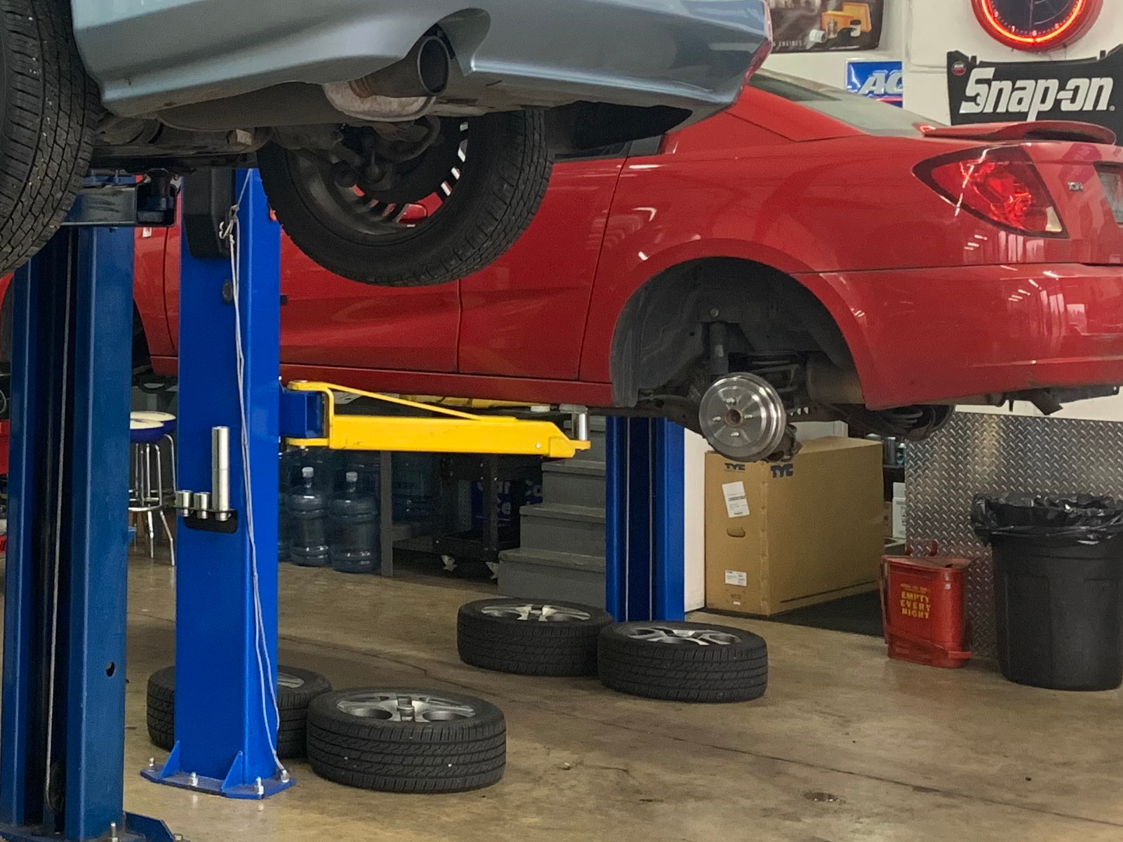 Brake rotor and brake service in progress on vehicle lifted at Local Wrench Auto Repair